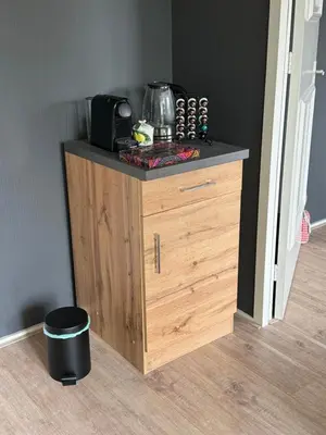 a wooden cabinet with a microwave on top of it at Ontbijt bij De Boerenmeid in Hoogwoud