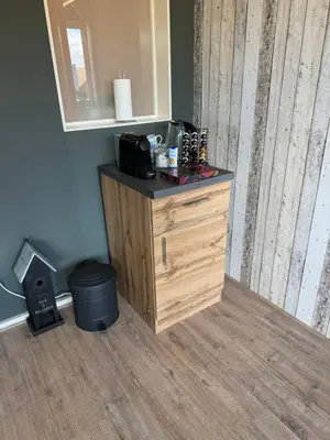 a wooden dresser in a room with a mirror at Ontbijt bij De Boerenmeid in Hoogwoud