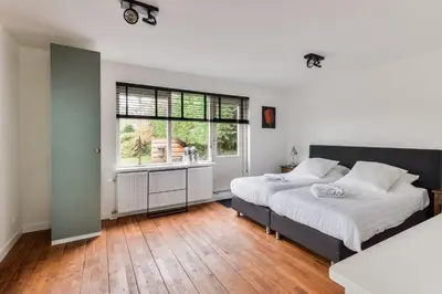 a bedroom with two beds and a window at Luxury Garden View Apartment in Zandvoort
