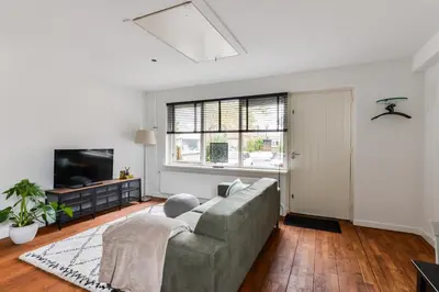 a living room with a couch and a tv at Luxury Garden View Apartment in Zandvoort