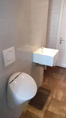 a bathroom with a white toilet and a sink at B&B Hart van Leiden in Leiden
