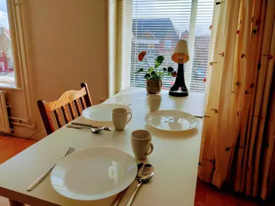 a white table with two white plates and a window at B&B Hart van Leiden in Leiden