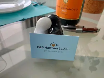 a bottle of wine sitting on a table with a napkin at B&B Hart van Leiden in Leiden