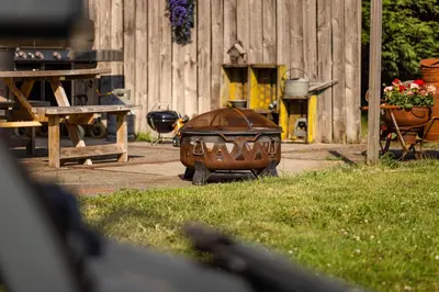 a large pot sitting in the grass next to a fence at Bed&Bbq Longhornranch in Akersloot