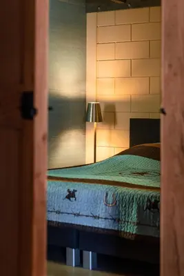 a bedroom with a bed with a lamp on it at Bed&Bbq Longhornranch in Akersloot