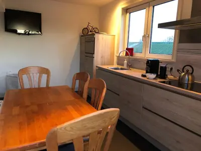 a kitchen with a wooden table and a kitchen with a sink at Amsterdam Twiskehouse in Den Ilp