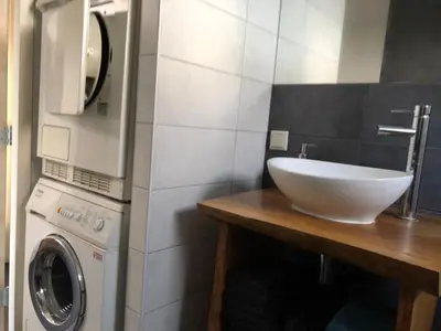 a bathroom with a sink and a washing machine at Amsterdam Twiskehouse in Den Ilp