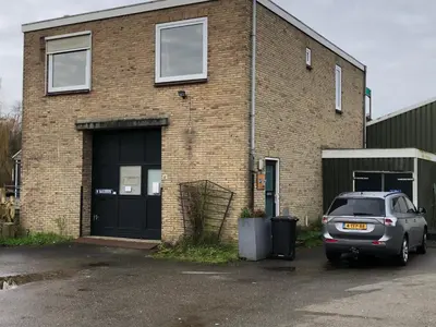 a car parked in front of a brick building at Amsterdam Twiskehouse in Den Ilp