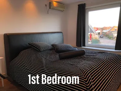 a black and white bed with two pillows and a window at Amsterdam Twiskehouse in Den Ilp