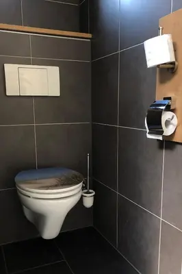 a bathroom with a toilet in a black wall at Amsterdam Twiskehouse in Den Ilp