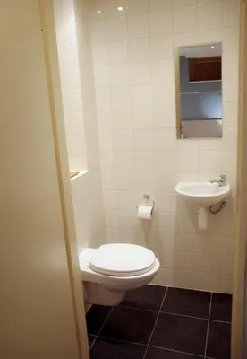 a bathroom with a toilet and a sink at Have a nice stay! - Le Souterrain in Noordwijk aan Zee
