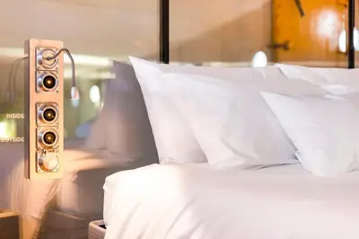 a bedroom with a bed with white pillows and a speaker at Lightship Amsterdam in Amsterdam