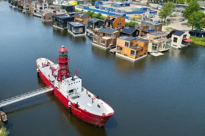 a red and white boat sitting in the water at Lightship Amsterdam in Amsterdam