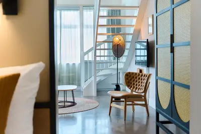 a room with a staircase and a chair and a table at Cityden BoLo District in Amsterdam