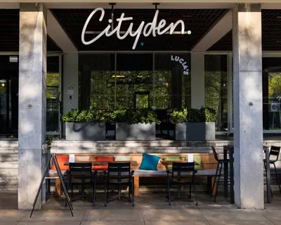 a restaurant with tables and chairs in front of a store at Cityden BoLo District in Amsterdam