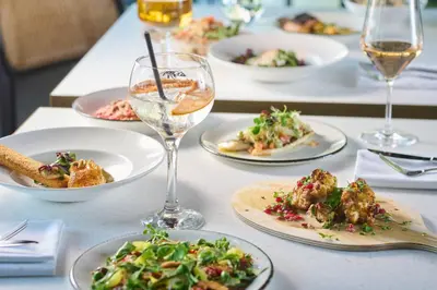 a table with plates of food and glasses of wine at Cityden BoLo District in Amsterdam