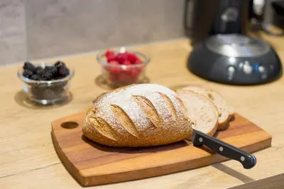 a loaf of bread on a cutting board with a knife at Studio Zonnehoek Schoorl in Schoorl
