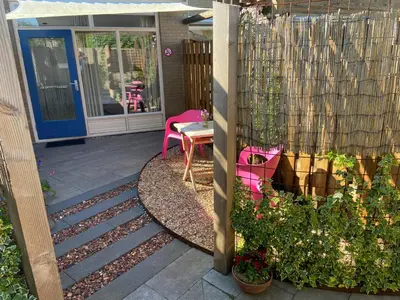 a patio with a table and chairs and a fence at Studio Zonnehoek Schoorl in Schoorl