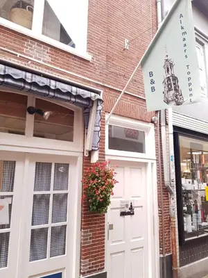 a building with a white door and a flag at B&B Alkmaars Toppunt in Alkmaar