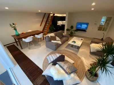 a living room with a couch and a table at Lake house 21 relax accommodation iR Sauna in Warmond