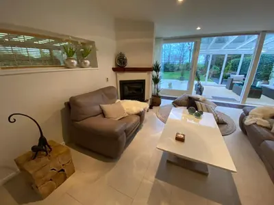 a living room with a couch and a table at Lake house 21 relax accommodation iR Sauna in Warmond