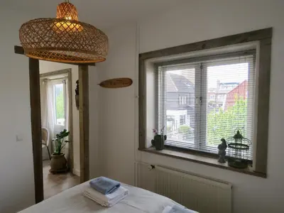 a bedroom with a window and a bed with towels at Casa duna close to the beach, city centre, dunes and parking area in Zandvoort