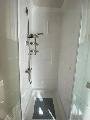 a bathroom with a shower with a tiled floor at Mevira Appartement in Zandvoort
