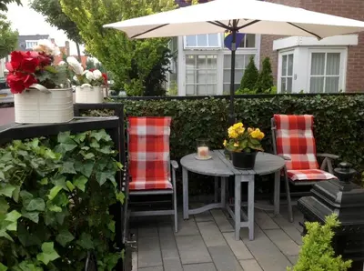 a patio with a table and chairs and an umbrella at Mevira Appartement in Zandvoort