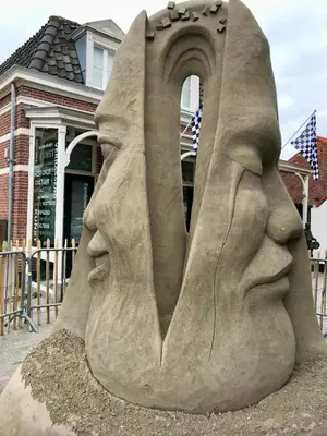 a sand sculpture of two faces in front of a building at Mevira Appartement in Zandvoort