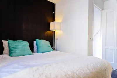 a bedroom with a large bed with blue pillows at Apartment Naarden-Vesting in Naarden
