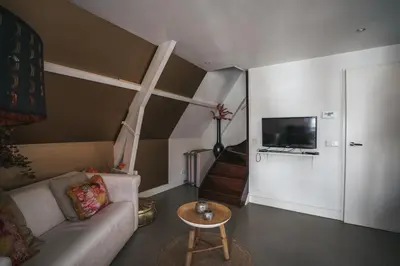 a living room with a couch and a tv at Apartment Naarden-Vesting in Naarden