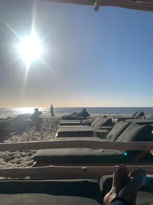 a group of beds on a beach with the sun at Apartment Naarden-Vesting in Naarden