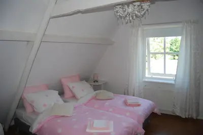 a bedroom with a pink bed and a window at Bed&Brood De StraVerdonk in Graft