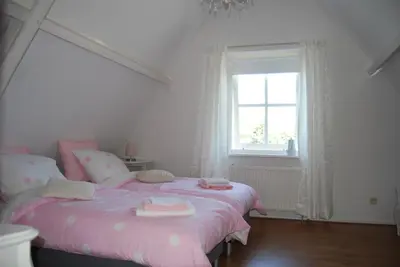 a bedroom with two beds with pink sheets and a window at Bed&Brood De StraVerdonk in Graft