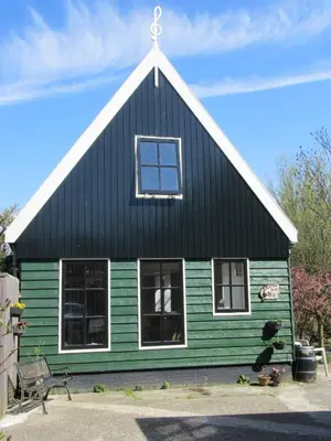 a green and black house with a white roof at Bed&Brood De StraVerdonk in Graft