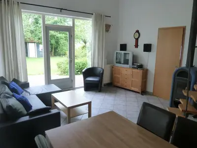 a living room with a couch and a tv and a table at Ferienhaus Lisakowski in Warmenhuizen