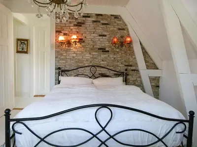 a bedroom with a bed with a brick wall at Ons Buiten in Bergen