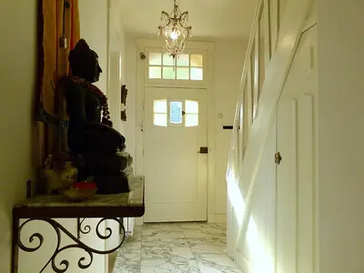 a hallway with a statue on a table and a door at Ons Buiten in Bergen