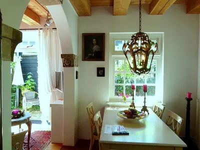 a dining room with a table and a chandelier at 't Kasteeltje in Bergen