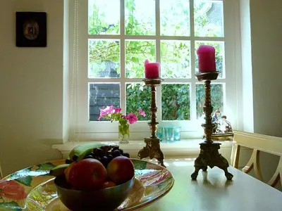 a bowl of fruit on a table with two candles at 't Kasteeltje in Bergen