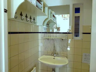 a white bathroom with a sink and a mirror at 't Kasteeltje in Bergen