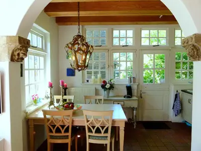 a kitchen with a table with chairs and a chandelier at 't Kasteeltje in Bergen