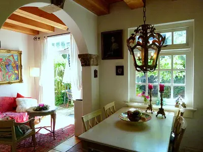 a dining room with a table and a chandelier at 't Kasteeltje in Bergen