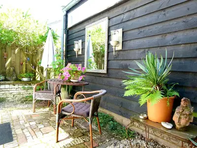 a patio with two chairs and a table with plants at 't Kasteeltje in Bergen