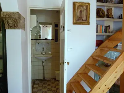 a bathroom with a sink and a bathroom with a staircase at 't Kasteeltje in Bergen