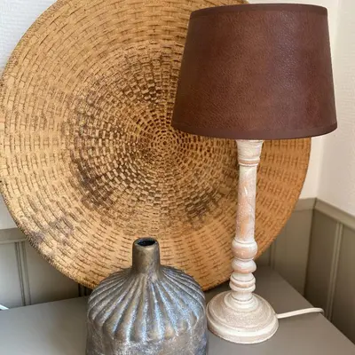 a lamp and a vase on a table next to a basket at Eureka Vakantiehuisjes in Schoorl