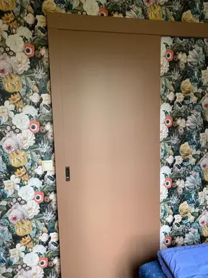 a door in a room with a floral wallpaper at Eureka Vakantiehuisjes in Schoorl