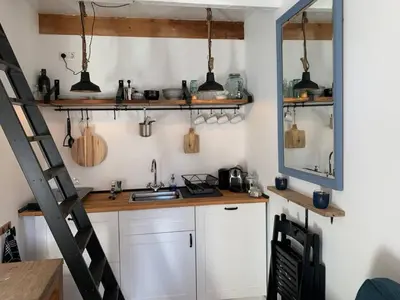 a kitchen with a counter and a ladder in a room at Have a nice stay! - Pelican Dune near the beach in Noordwijk aan Zee