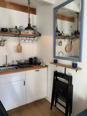 a kitchen with a mirror and a chair in a room at Have a nice stay! - Pelican Dune near the beach in Noordwijk aan Zee