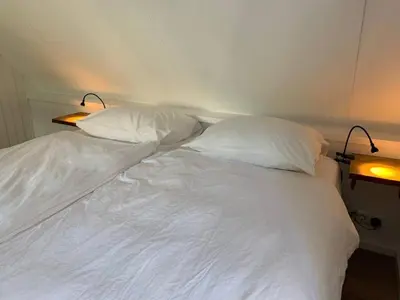 a white bed with two pillows and two lamps at Have a nice stay! - Pelican Dune near the beach in Noordwijk aan Zee